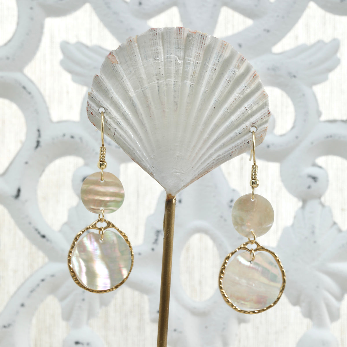 Boucles d'oreilles nacre irisée et or sur un présentoir éventail blanc. Atelier Sitaël