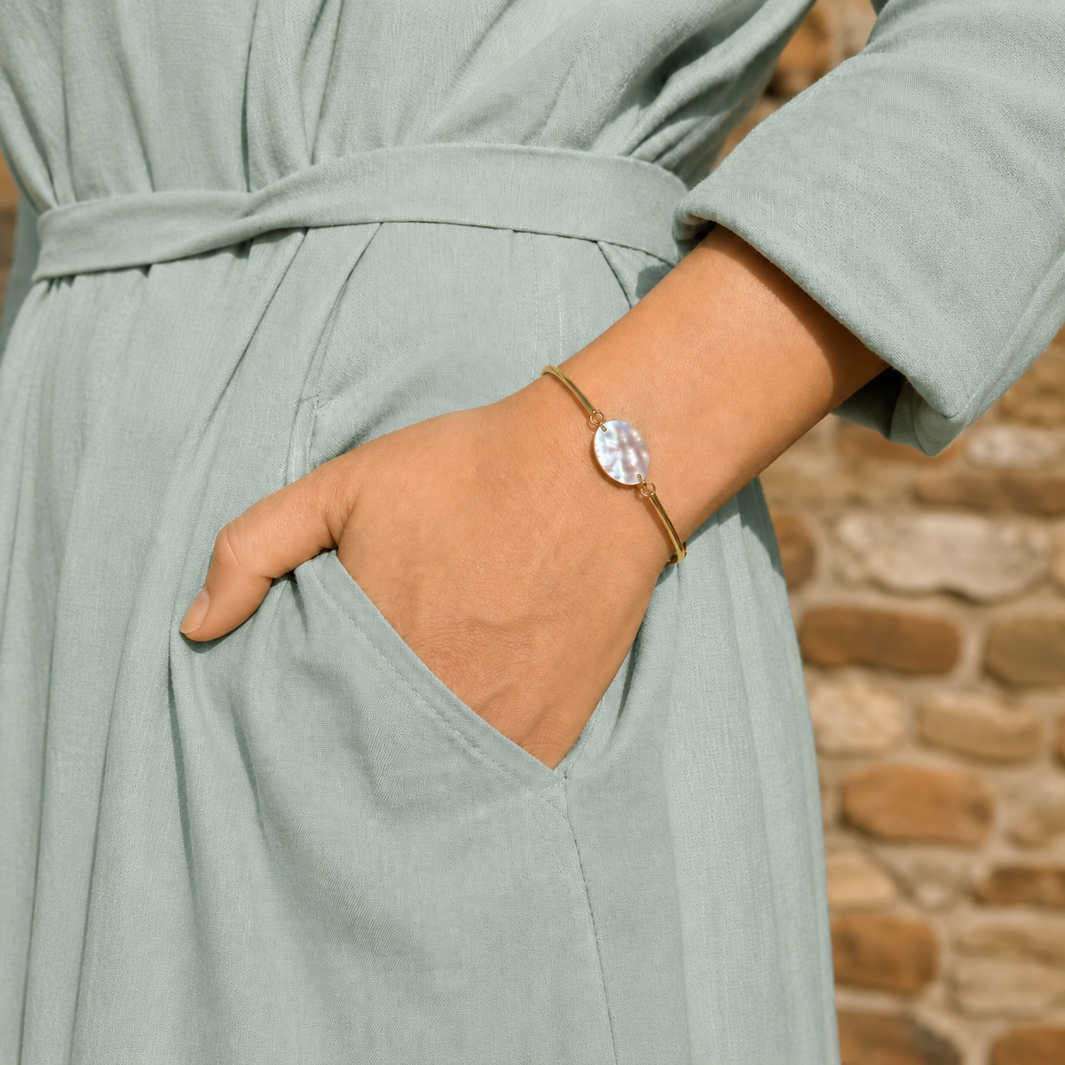 Bracelet jonc nacre et laiton porté au poignet. Atelier Sitaël