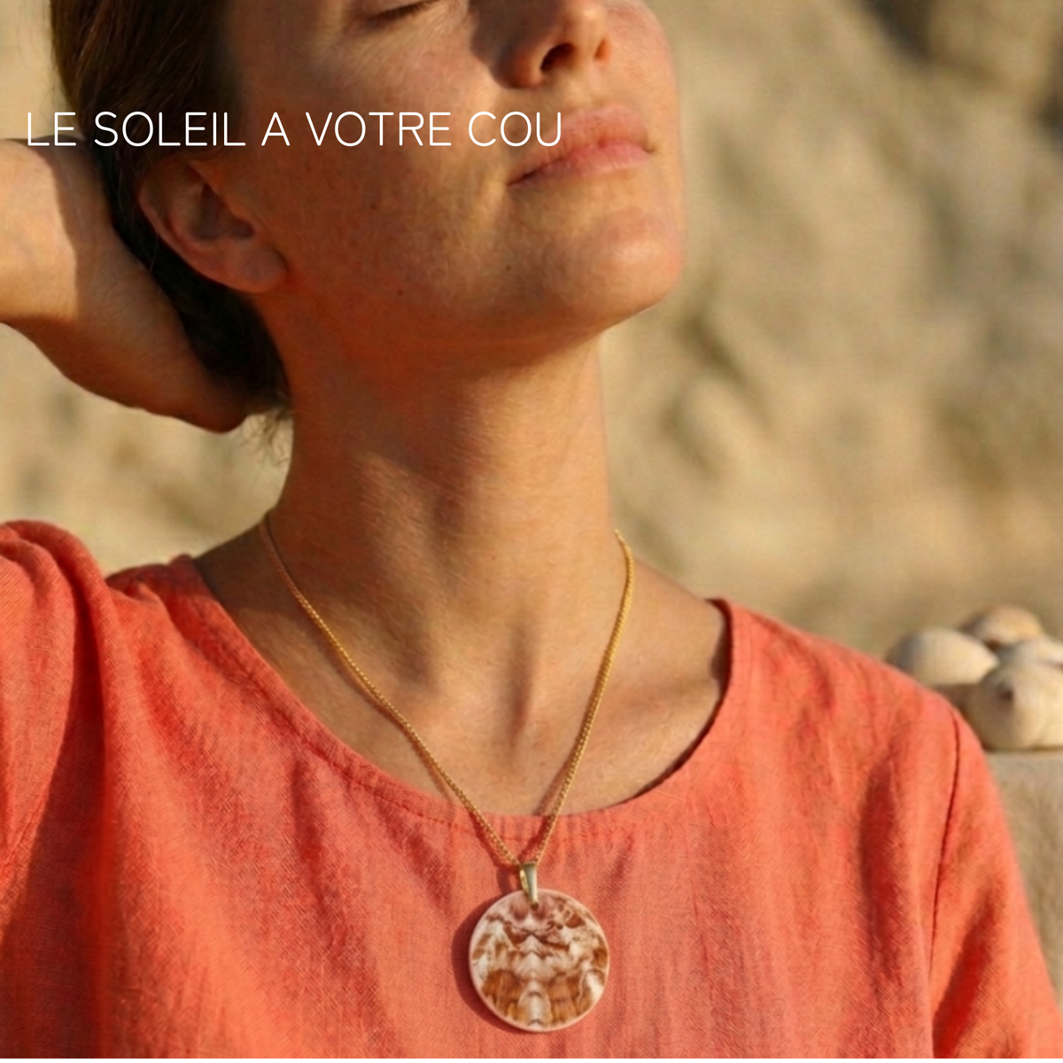 Femme portant un collier coquille Saint-Jacques doré avec un haut orange. Atelier Sitaël